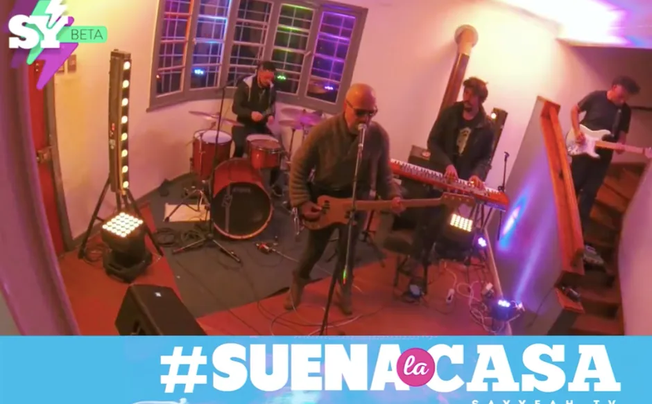 Banda tocando en vivo en un living, con el rótulo #SUENA la CASA sobreimpreso.